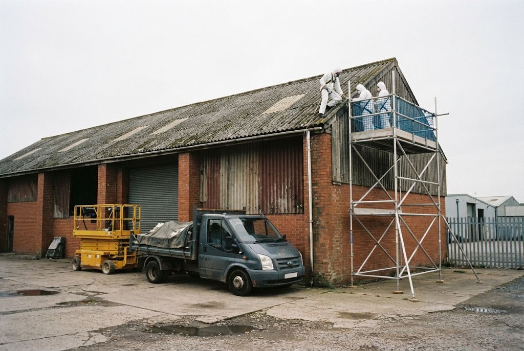 Crew working on an industrial unit roof from a scaffold tower
